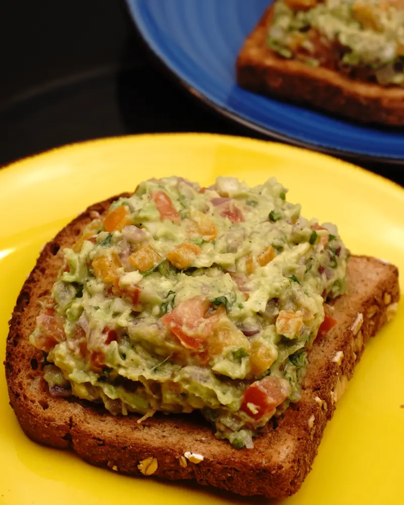 Avocado Veggie Salad Open Sandwich - close up view of finished dish plated and garnished