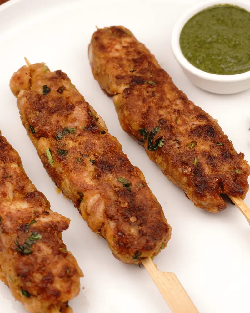 Restaurant Style Chicken Seekh Kebab - close up view of finished dish plated and garnished