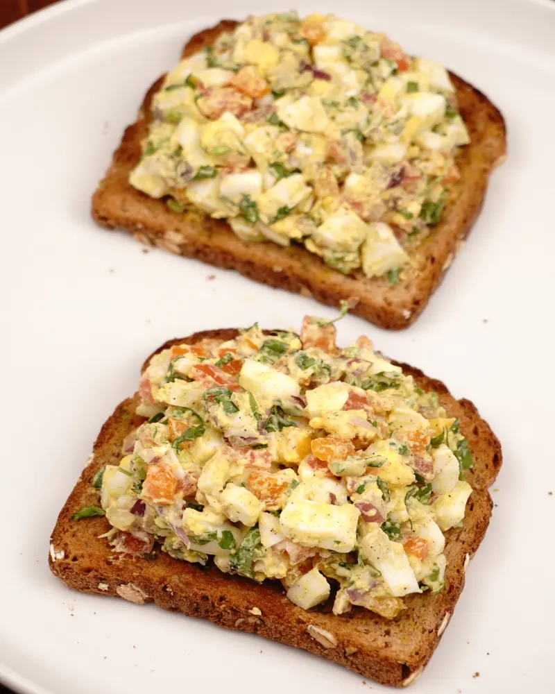 Curd Egg Veggie Salad Open Sandwich - close up view of finished dish plated and garnished