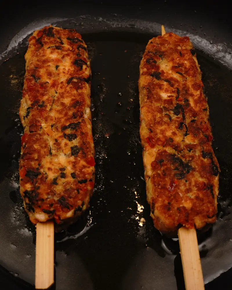 Veggie Loaded Fish Seekh Kebab - close up view of finished dish plated and garnished