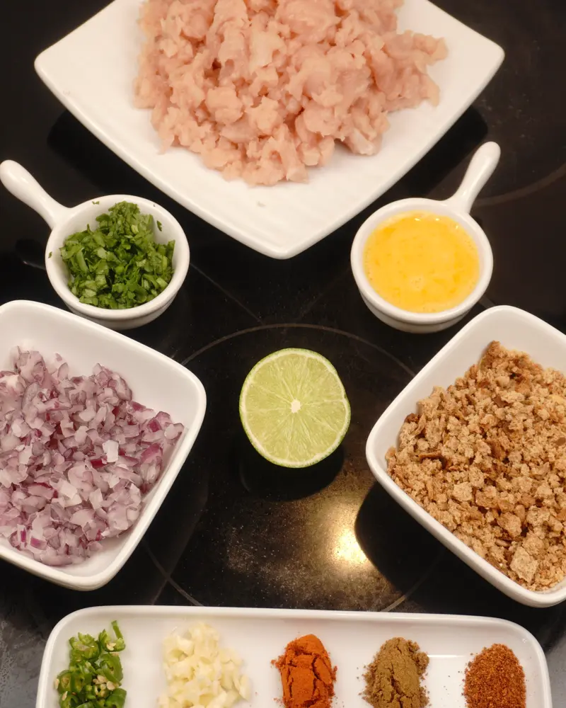 Ingredients for Low Calorie Chicken Seekh Kebab including Coarse chicken breast, Finely chopped onion, Finely chopped garlic