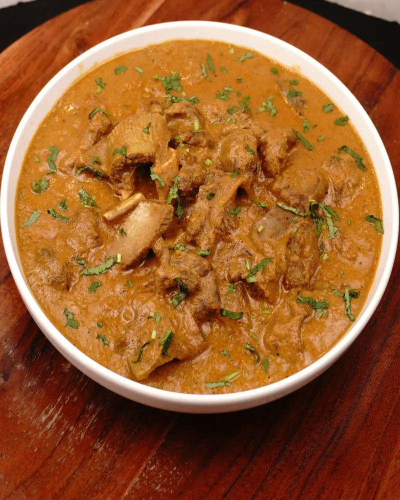 Pot-Cooked Mutton Curry (Baby Goat) — Restaurant Style - close up view of finished dish plated and garnished