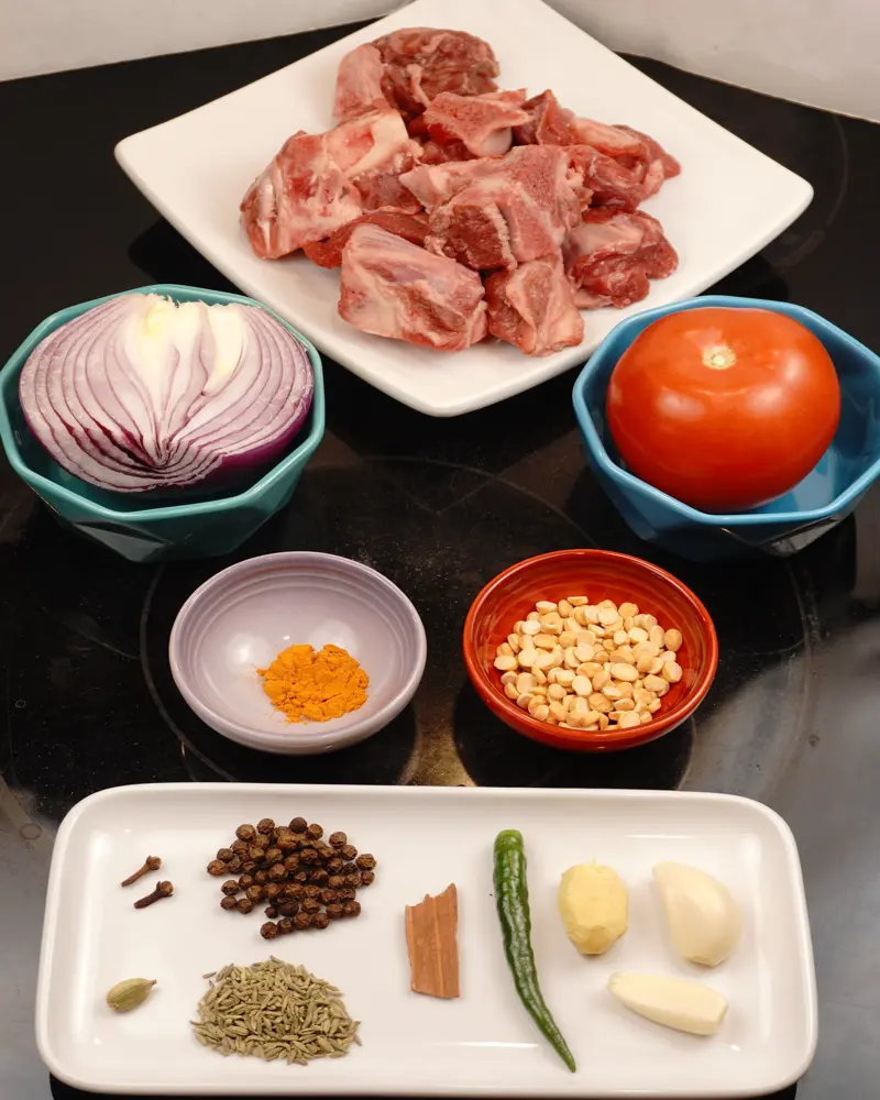 Ingredients for Baby Goat Mutton Shorba (Soup) including Baby goat bone in pieces, Red Onion or Shallots, Tomato
