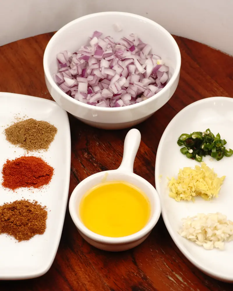 Ingredients for Perfect Pan-Grilled Chicken patty Kebab – Restaurant Style at Home including Boneless chicken leg pieces, Chopped onion, Chopped Green chili