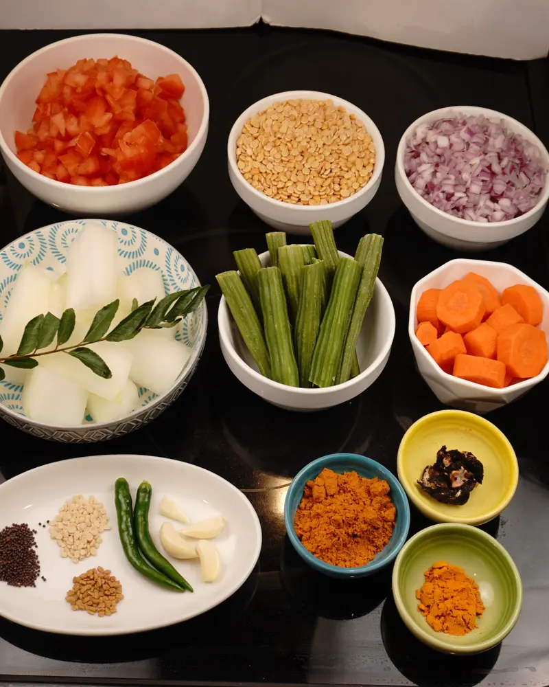 Ingredients for Restaurant Style Vegetable Sambar including Toor dal (pigeon peas), Red Onion or Shallots, Tomatoes