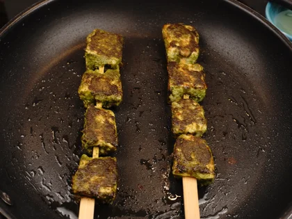 Low Carb, Less Oil Hariyali Tikka  - Cook on both thin sides of the skewers on medium flame then flip flat side