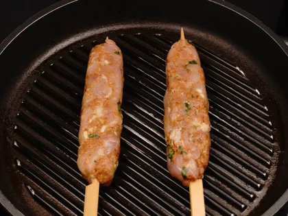 Place the oiled surface chicken skewers on the hot grill pan and continue to cook them without moving, untill to attain dark brown grill marks underside the chicken skewers for about 4 to 5 minutes over medium flame 