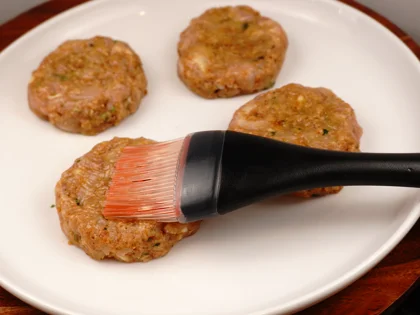 Prepare liquid ghee, just before placing them on hot pan, use pastry brush to apply ghee on top surface of the chicken patties   