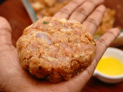 Apply oil on your hands, take one portion of chicken mixture to form a loosely packed ball then lightly flatten the ball at the top to form circular shape chicken patty 