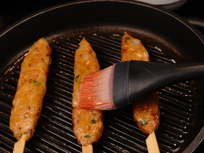 Just before flip them, baste oil on top side of the chicken skewers then flip them & reduce the heat to low  