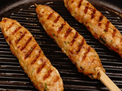Just before flip them, baste oil on top side of the chicken skewers then flip them & reduce the heat to low  