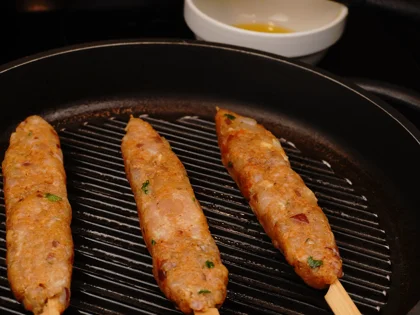 Place the oiled surface chicken skewers on the hot grill pan and continue to cook them without moving, untill to attain brown grill marks underside the chicken skewers for about 4 to 5 minutes over medium flame 