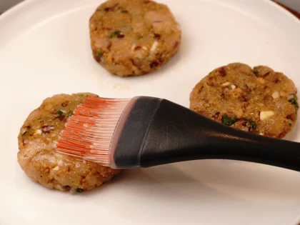 Just before placing them on hot pan, use pastry brush to apply oil on top surface of the chicken patties 