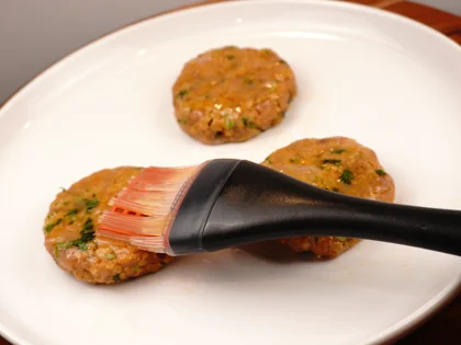 Prepare liquid ghee, just before placing them on hot pan, use pastry brush to apply ghee on top surface of the chicken patties   