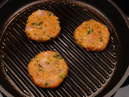 Place the oiled surface chicken patties on the hot grill pan and continue to cook them without moving, untill to attain dark brown grill marks underside the chicken skewers for about 4 to 5 minutes over medium flame 