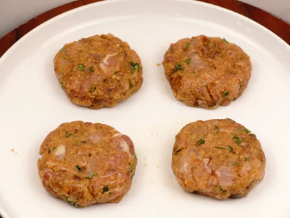 Apply oil on your hands, take one portion of chicken mixture to form a loosely packed ball then lightly flatten the ball at the top to form circular shape chicken patty 