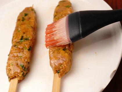Prepare liquid ghee, just before placing them on hot pan, use pastry brush to apply ghee on top surface of the chicken skewers   