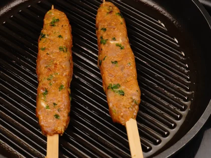 Place the oiled surface chicken skewers on the hot grill pan and continue to cook them without moving, untill to attain dark brown grill marks underside the chicken skewers for about 4 to 5 minutes over medium flame 
