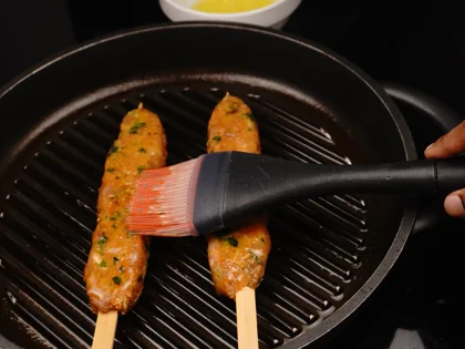 Just before flip them, baste ghee on top side of the chicken skewers then flip them & reduce the heat to low  
