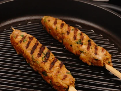 Just before flip them, baste ghee on top side of the chicken skewers then flip them & reduce the heat to low  