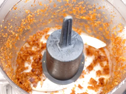 First grind coarsely only the one portion of onion masala mixture then add one portion of chicken pieces  